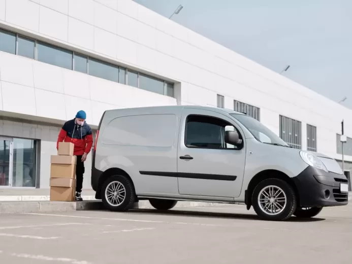 Delivery Man With Boxes next to a White Van