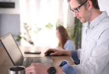 man in blue dress shirt using computer