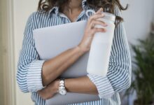 woman in white and blue stripe shirt holding white ceramic mug