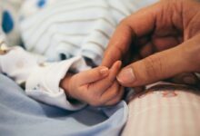 person holding baby's index finger