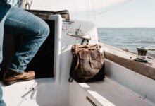 person in blue denim jeans on yacht beside brown bag
