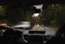 a person driving a car on a road with traffic lights