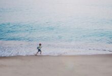 person running on seashore during daytime