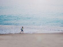 person running on seashore during daytime