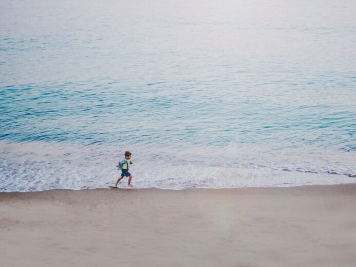 person running on seashore during daytime