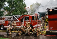 a group of firefighters standing next to a fire truck