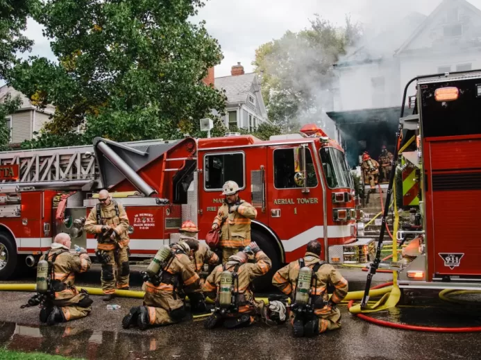 a group of firefighters standing next to a fire truck