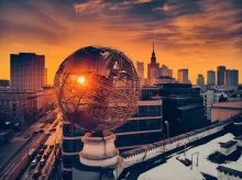 white round globe statue near city buildings during night time