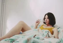 woman in yellow shirt lying on bed