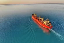 red and white cargo ship at middle of ocean