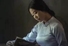 woman wearing gray long-sleeved tops reading book