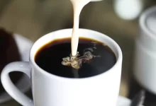 coffee in white ceramic mug while pouring milk