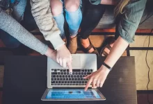 three person pointing the silver laptop computer