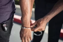 Police Officer Putting Handcuffs on Another Person