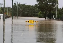 a flooded street with a yellow sign