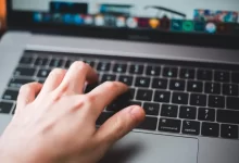 person using macbook pro on table