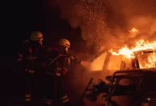 2 men in black helmet standing near fire