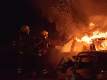 2 men in black helmet standing near fire