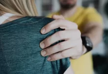 A Man Squeezing a Woman's Shoulder