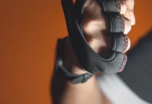 a close up of a person holding a pair of gloves
