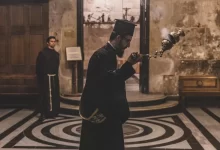 man holding incense burner inside building