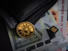 a bitcoin sitting on top of a pile of money