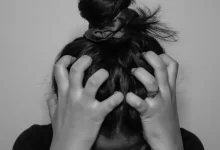 a woman covering her face with her hands