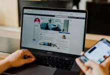 person using both laptop and smartphone
