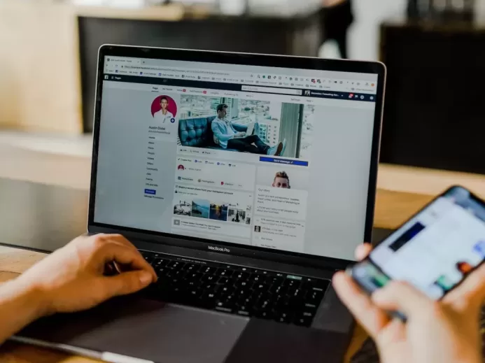 person using both laptop and smartphone
