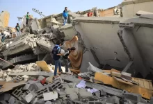 a group of people standing next to a collapsed building