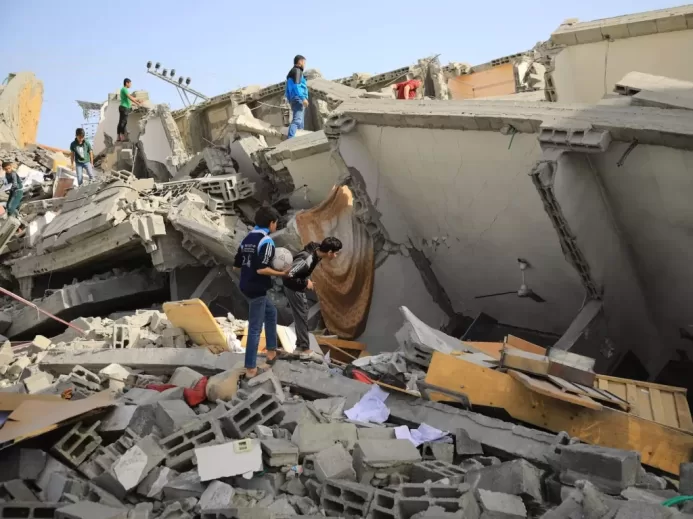 a group of people standing next to a collapsed building