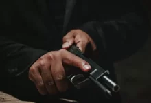 a man holding a gun in his right hand