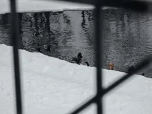 person in black jacket and black pants sitting on snow covered ground during daytime