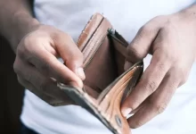 person holding brown leather bifold wallet