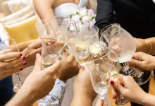 woman in white wedding dress holding clear wine glass