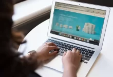 woman using MacBook Air on table