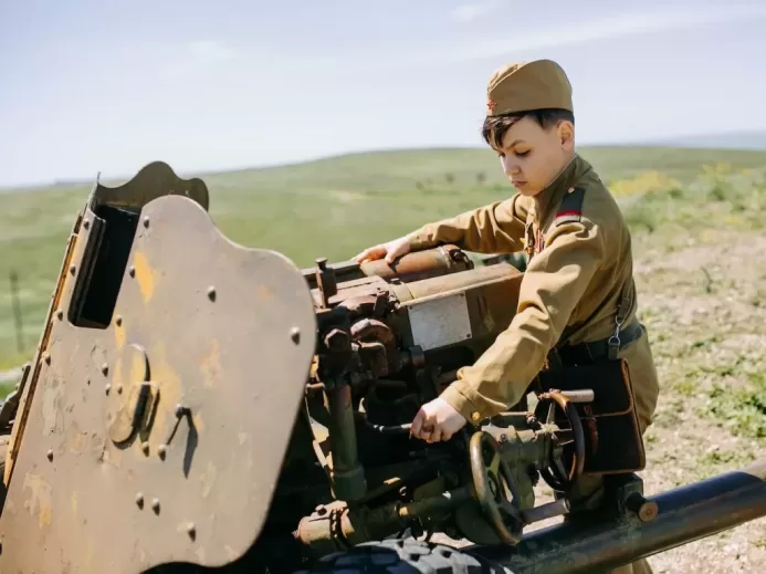 a boy in a military uniform working on a machine