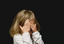 girl covering her face with both hands