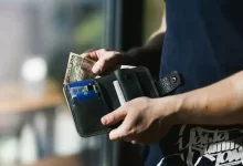 Photograph of Person Holding Black Leather Wallet with Money