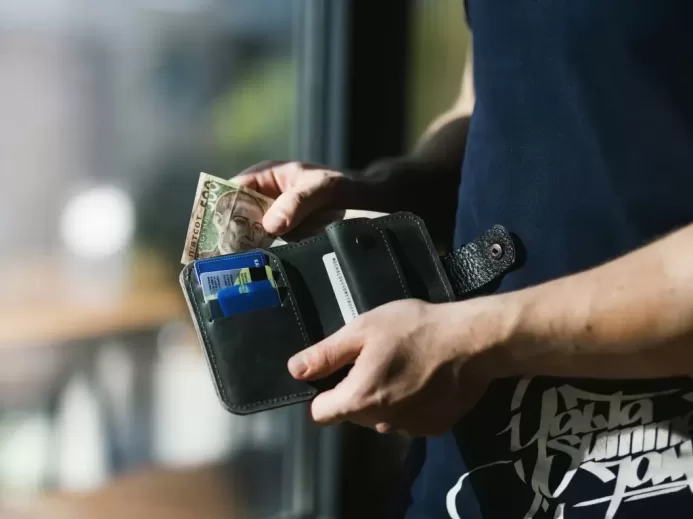 Photograph of Person Holding Black Leather Wallet with Money