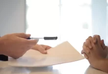Crop businessman giving contract to woman to sign