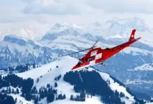 photo of flight of red and white rescue helicopter during snow daytime