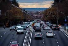 a street filled with lots of traffic next to tall buildings