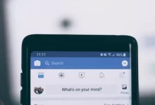 person holding smartphone using facebook account