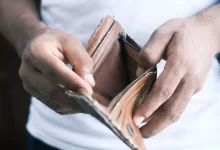 person holding brown leather bifold wallet