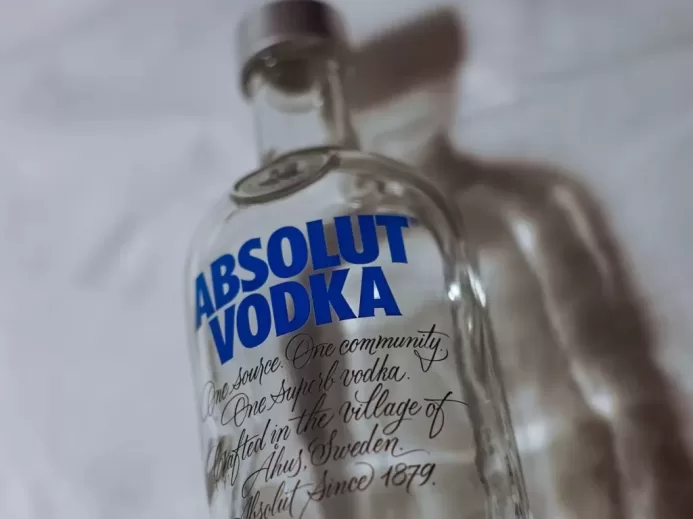 clear glass bottle on white textile