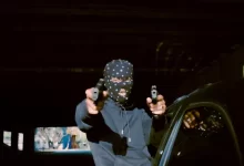 a person sitting on a car holding a camera