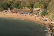 A beach with a bar and a few people on it