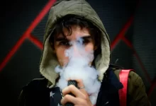 man in hoodie vaping