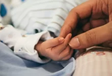 person holding baby's index finger